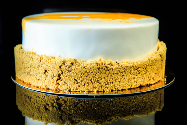 gâteau au musc blanc brillant recouvert de glaçure blanche et jaune sur fond noir de côté
 - Photo, image
