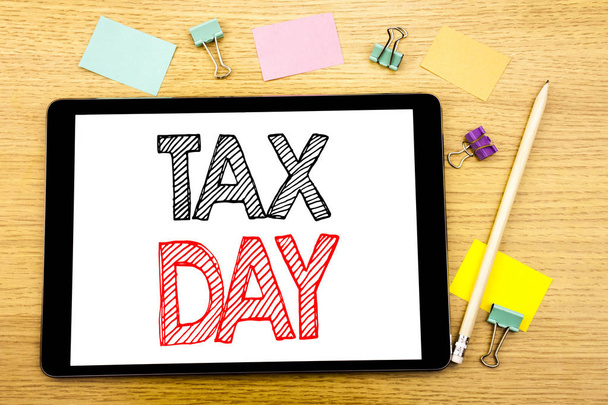 Writing text showing Tax Day. Business concept for Income taxation Refund Written on tablet laptop, wooden background with sticky note and pen - Photo, Image