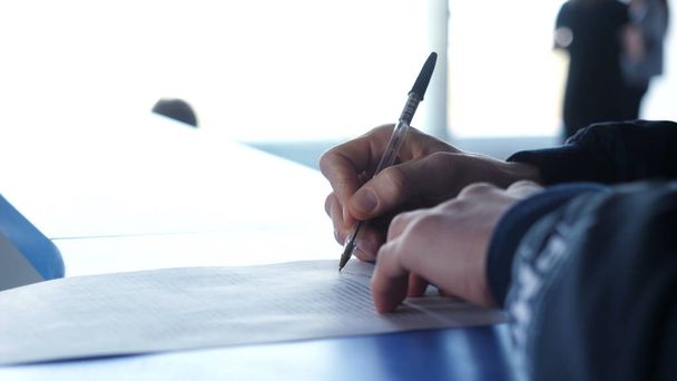 Close-up van mannelijke handen met pen over document. Man ondertekent het contract close-up - Foto, afbeelding