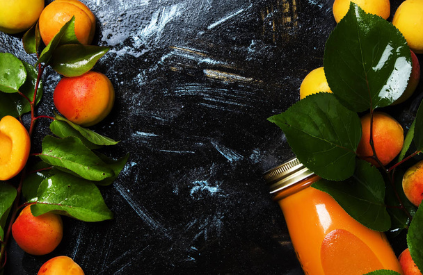 Freshly squeezed apricot juice in glass bottle, black food background, top view   - Fotografie, Obrázek