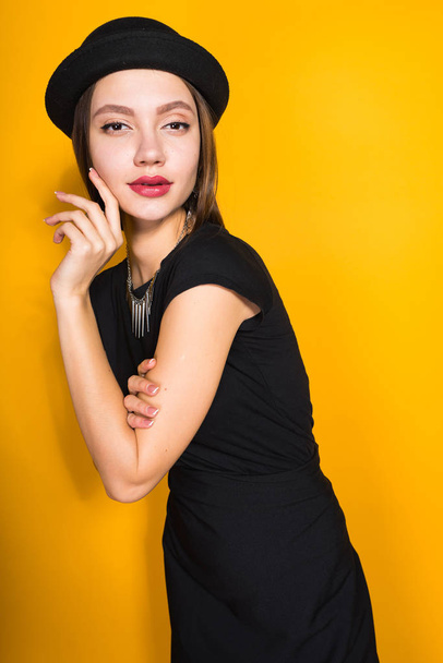 attractive young girl in black dress and hat posing, demonstrating expensive jewelry - Φωτογραφία, εικόνα