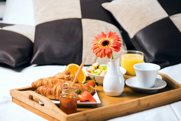 Tray with breakfast food on the bed inside a bedroom - Photo, Image
