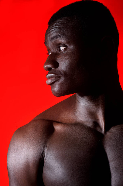 portrait of an african man shirtless on red background - Foto, afbeelding