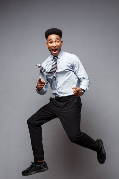 Business Concept - Ritratto integrale di un uomo d'affari afroamericano di successo che salta felice in ufficio
.  - Foto, immagini