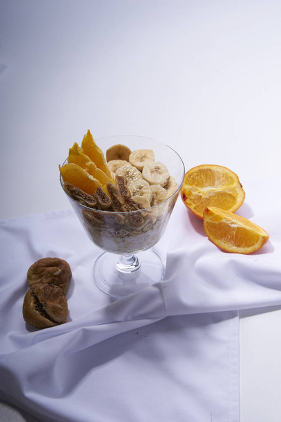 gesundes Frühstück auf weiß. Haferflocken mit Joghurt, Feigen, Banane und Orange - Foto, Bild