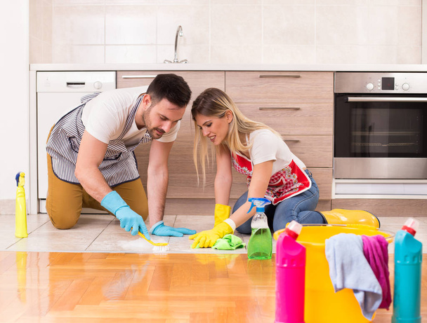 Jeune couple nettoyage maison ensemble
 - Photo, image