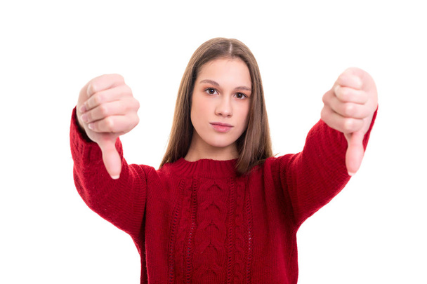 Studio shot of a young woman signaling thumbs down, isolated over white background - Foto, afbeelding
