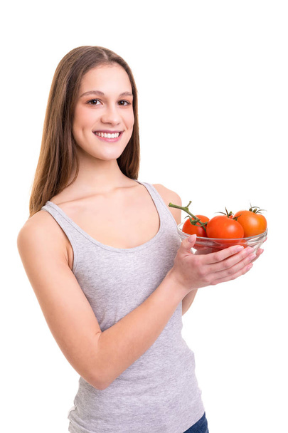 いくつかの新鮮なトマトを保持している若い女性。白い背景。健康的な食事のコンセプトです。ダイエット. - 写真・画像