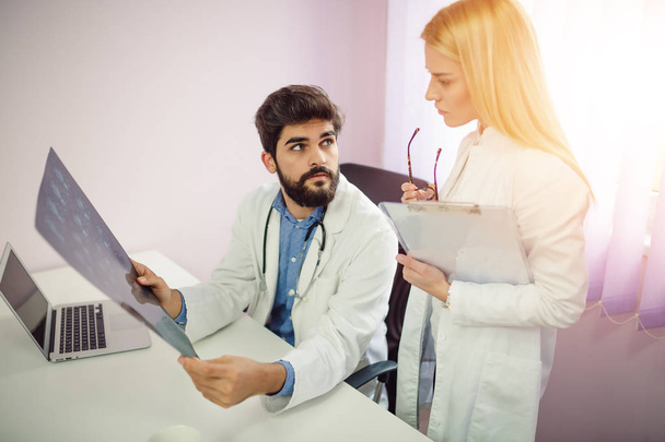 Здравоохранение, медицинская и радиологическая концепция - два врача смотрят на рентген - Фото, изображение