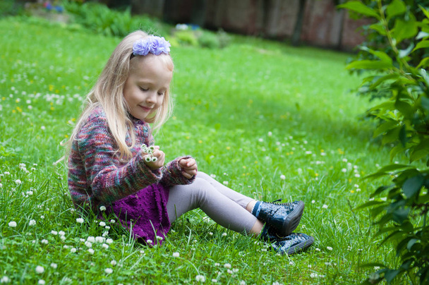 pieni kaunis vaalea tyttö nurmikolla
 - Valokuva, kuva