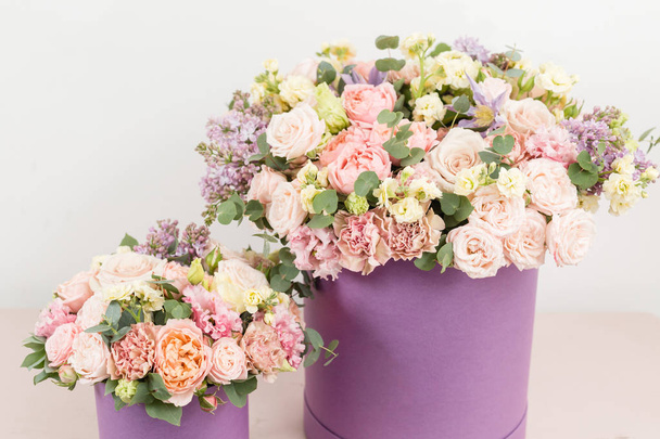 όμορφο πολυτελές μπουκέτο μικτή λουλούδια στο ροζ πίνακα. το έργο του το ανθοπωλείο σε ένα ανθοπωλείο. ανθοδέσμη σε λιλά hatbox. τέλειο δώρο ή φιλοφρόνηση. - Φωτογραφία, εικόνα