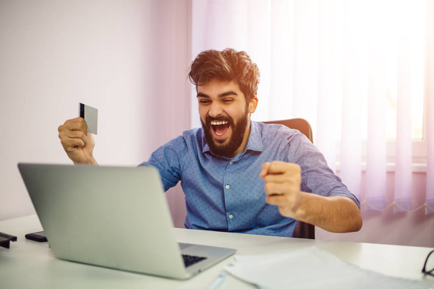 glücklicher Mann feiert erfolgreichen Online-Einkauf, Kreditkartenzahlung. - Foto, Bild