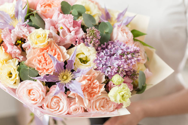 Bouquet von zarter Pastellfarbe. schöner luxuriöser Strauß gemischter Blumen in Frauenhand. die Arbeit der Floristin in einem Blumenladen. - Foto, Bild