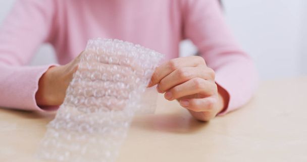 Mujer jugar con la envoltura de burbujas para aliviar el estrés
  - Foto, Imagen