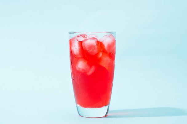 Содовая. Красная газированная вода со льдом в стакане
 - Фото, изображение