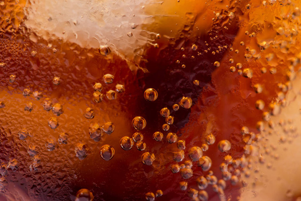 Macro of bubbles and fizz. A cool glass of cola drink with ice - Photo, Image