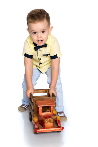 A little boy is playing with a toy car. - Φωτογραφία, εικόνα