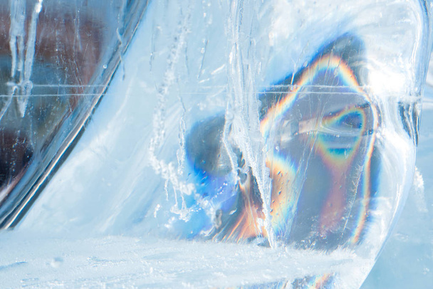 Mooie blauwe textuur van transparante winter ijs met regenboog co - Foto, afbeelding