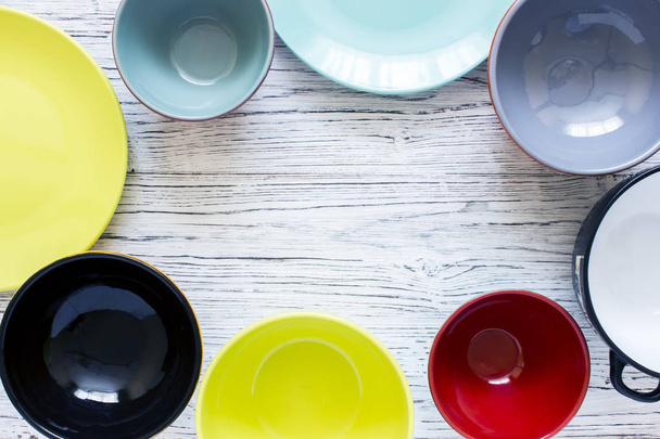 Άδειο χρώμα πιάτα και σκεύη σε ξύλινο τραπέζι φόντο, το top view με αντίγραφο χώρου - Φωτογραφία, εικόνα