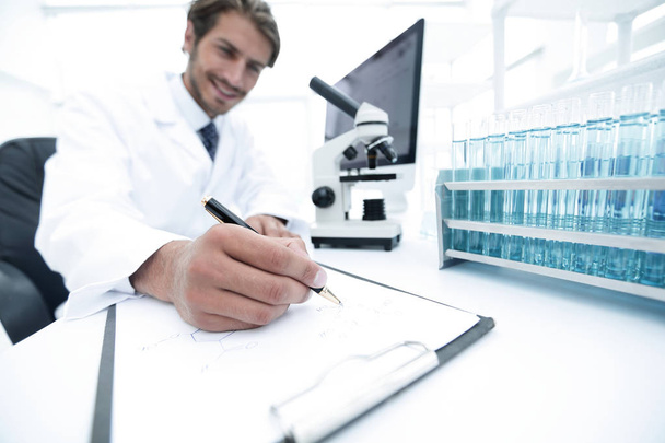 scientist makes a note of experiment in the laboratory - Foto, Imagen
