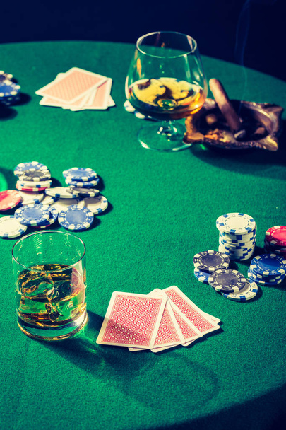 Closeup of green table for poker with whiskey and cards - Fotoğraf, Görsel