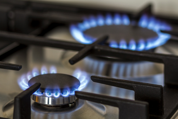 キッチンのガスの燃焼ガスは、暗闇の中でストーブ。黒の背景、クローズ アップ撮影にガスこんろバーナーと鋼からパネル - 写真・画像