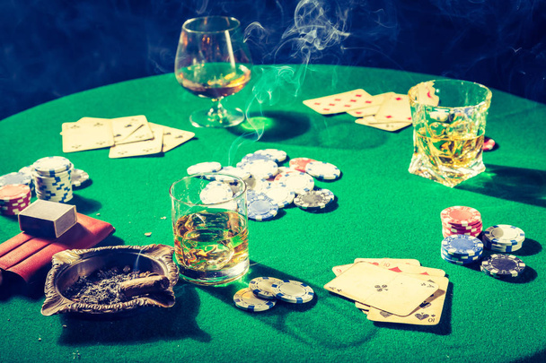Vintage gambling green table with chips and cards - 写真・画像