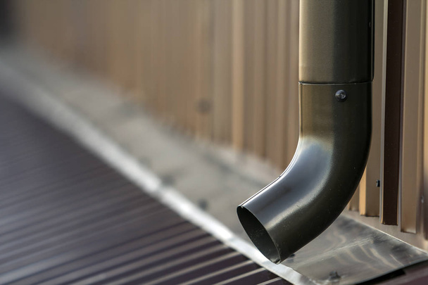 Kahverengi yeni cilt payı metal sistem boru. Duvardaki çatı binadan yağmur suyu drenaj için dikey inşaat. Drenaj koruma. - Fotoğraf, Görsel