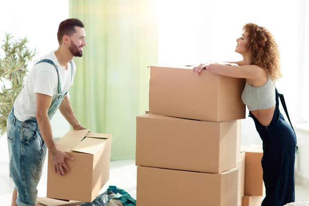 pareja joven desempacando cajas en una casa nueva
 - Foto, imagen