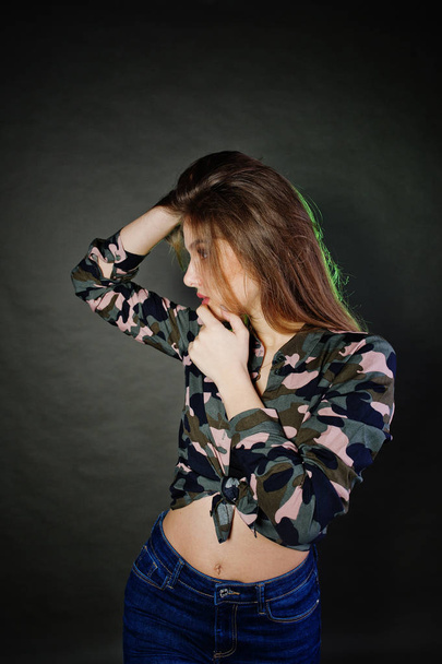 Handsome brunette girl wear military shirt and jeans, posing at  - Фото, зображення