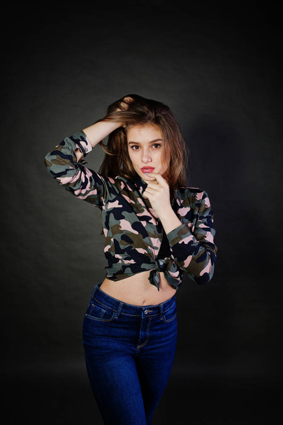 Handsome brunette girl wear military shirt and jeans, posing at  - 写真・画像
