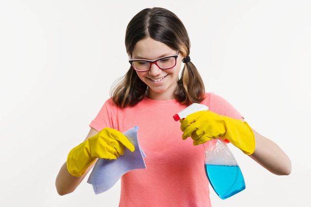 Cleaning day, spring cleanup, housework concept. Girl teenager in yellow gloves with rag and spray detergent. - Photo, Image