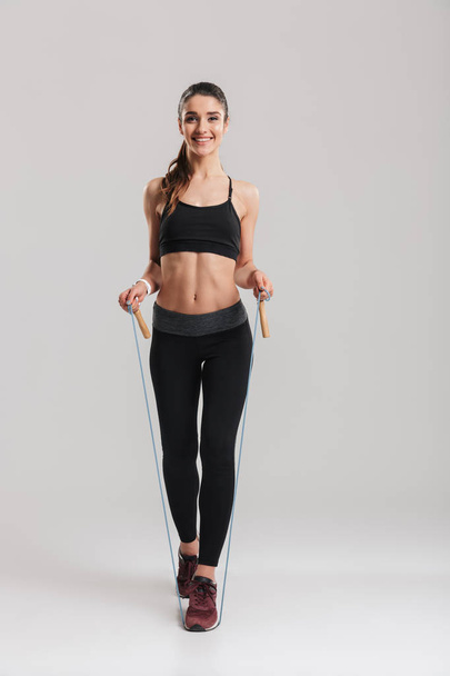 Full-length picture of joyous woman in gym smiling on camera and - Foto, Imagem