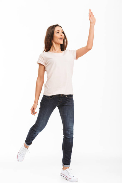 Full length image of Cheerful brunette woman in t-shirt walking - Foto, Bild