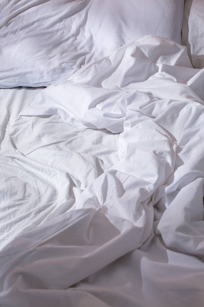 ein zerknittertes weißes Bett - Foto, Bild