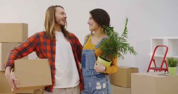 Portrét mladého atraktivního muže a ženy stojících před kamerou a pózujících s krabicí a květinami v rukou. Jdeme na to. Uvnitř - Záběry, video