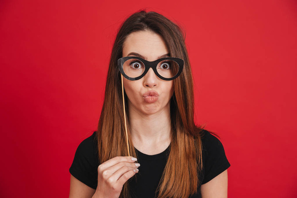 Portrait of a cute girl having fun with fake eyeglasses - Foto, Imagem