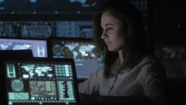 Porträt einer jungen Programmiererin, die an einem Computer im Rechenzentrum mit Bildschirmen arbeitet - Filmmaterial, Video