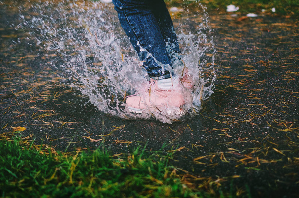 Ένα κορίτσι που άλματα σε το puddle - Φωτογραφία, εικόνα