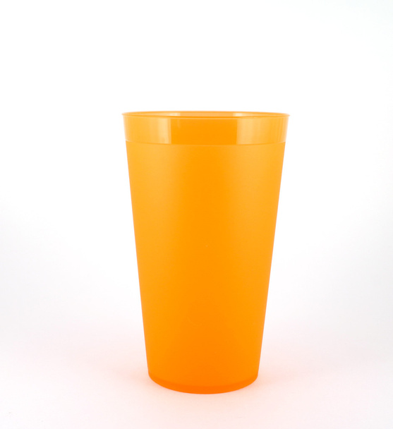 Помаранчева пластикова чашка над білим
 - Фото, зображення