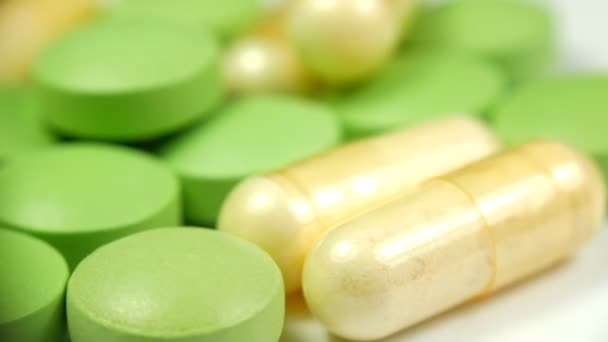 Close-up wit groene pillen op een witte achtergrond draaien - Video