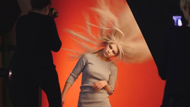 Flowing hair of attractive model girl in photo studio, slow-motion - Photo, Image