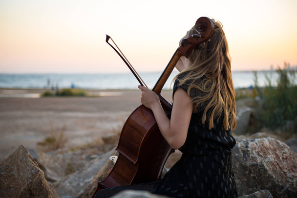 Jeune belle fille avec son violoncelle à l'extérieur
 - Photo, image