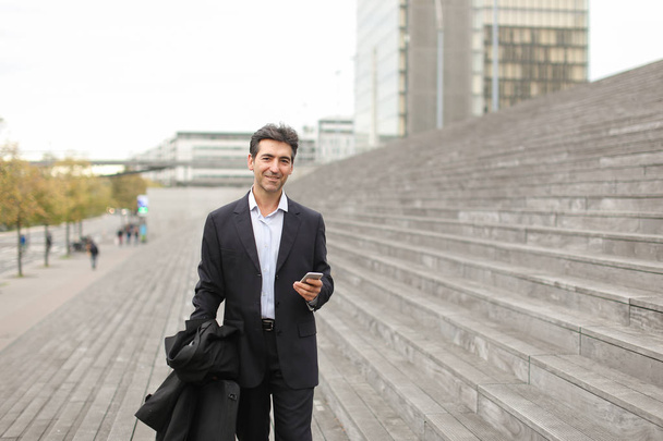      business man walking using smartphone to watch photos. - Photo, Image