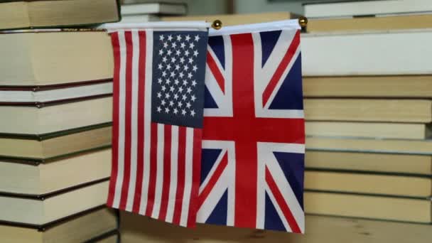De Amerikaanse vlag en de vlag van Groot-Brittannië en papieren boeken. - Video