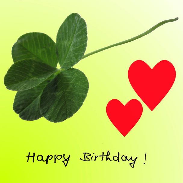 Pięciolistna koniczyna zdjęcie zielony z dwa czerwone serca i odręczny "Happy Birthday" na lime green. - Zdjęcie, obraz