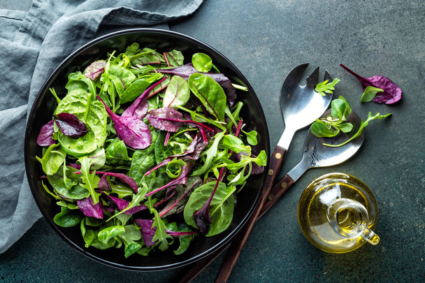 Φρέσκια σαλάτα μείγμα από φύλλα ρόκα, βασιλικό, σπανάκι, σέσκουλα και αρνιά μαρούλι. Σαλατιέρα, υγιεινά τρόφιμα, το top view - Φωτογραφία, εικόνα