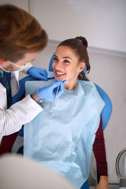 Female patient showing beautiful teeth to dentist - Zdjęcie, obraz