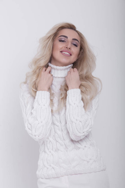 Gorgeous young blonde woman in warm knitted sweater on light grey background - Foto, Imagem