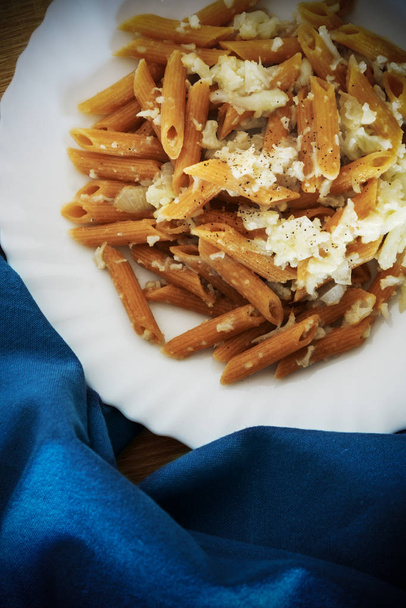 Volkoren pasta en bloemkool plaat door een blauw servet - Foto, afbeelding